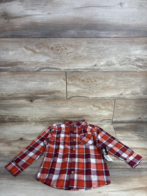 Red and orange plaid long sleeve button-up shirt for kids on wooden background