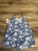Blue baby romper with white tropical palm tree and surfboard print, laid on wood background.