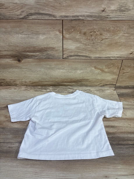 Flat lay of white Jordan shirt in size 5T showcasing short sleeves and crew neck on a wood surface