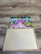 Overhead view of Melissa & Doug 24-piece wooden jigsaw puzzle showing a princess in a purple dress with forest animals on a wooden storage board