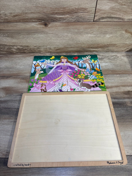 Overhead view of Melissa & Doug 24-piece wooden jigsaw puzzle showing a princess in a purple dress with forest animals on a wooden storage board