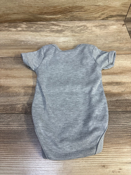 Flat view of grey Battery bodysuit in size 0 to 3 months showcasing short sleeves on a wood grain surface