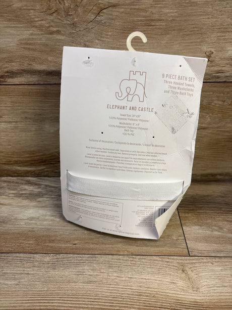 Back of Elephant and Castle bath towel set packaging showing brand logo, care instructions, and hanger on wood background