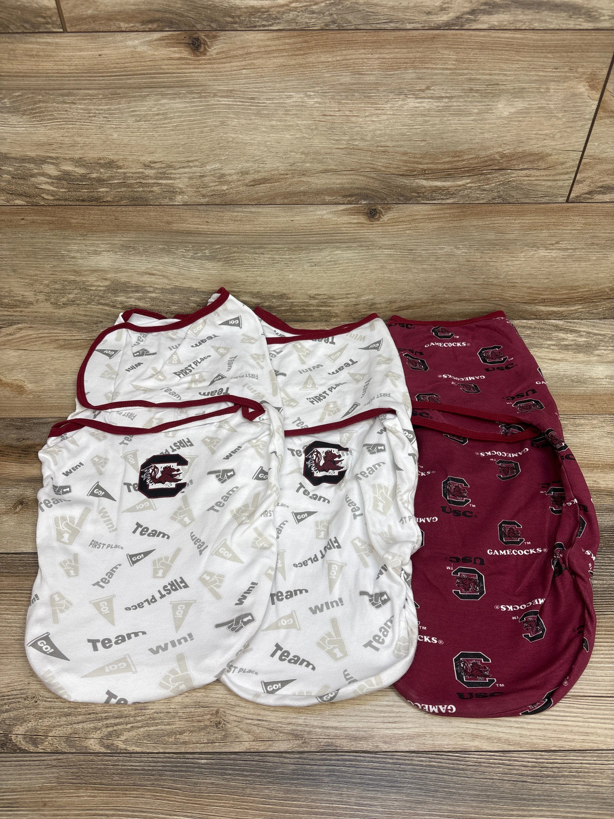 Top view of three South Carolina Gamecocks swaddle wraps in white and garnet with team logos and patterns