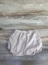 Top view of beige H&M cotton jersey baby bloomers showing elastic waistband and gathered leg openings on wood background