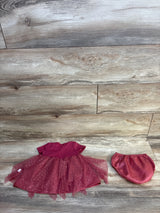 Pink baby dress with sparkling tulle skirt and matching diaper cover on wooden background