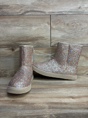 Sparkly pink glitter kids boots with rubber soles on a wooden background