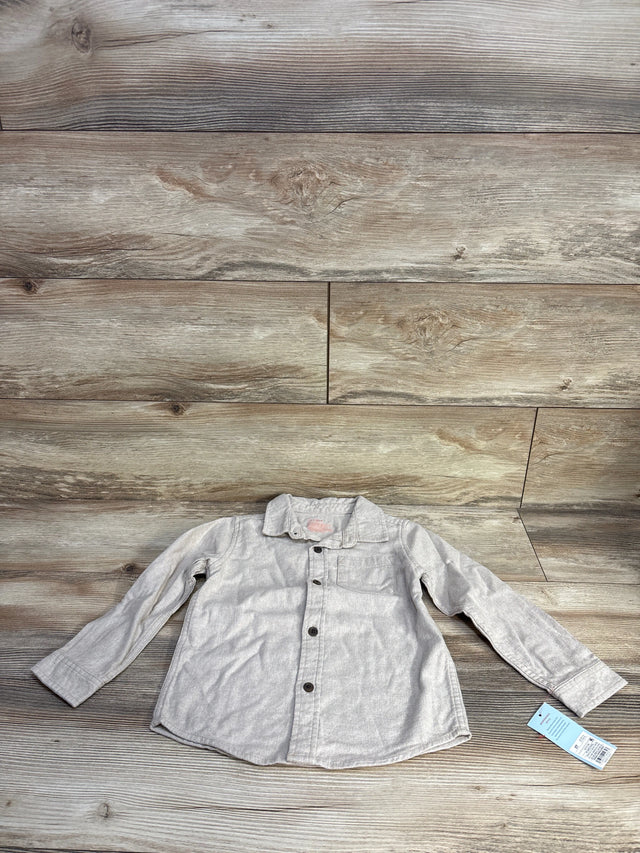 Flat lay of beige Cat and Jack 5T button-up kids shirt showing front buttons, chest pocket, long sleeves on wood background