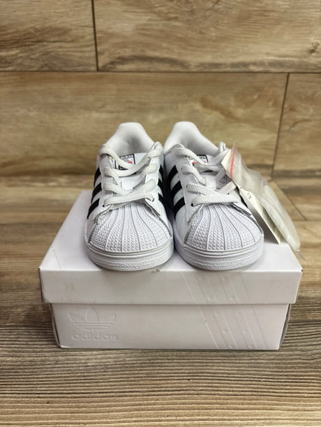 Front view of Run DMC x Adidas Superstar 50th Anniversary sneakers with black stripes on a white Adidas shoebox