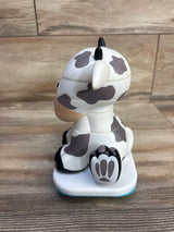 Side view of Stack-a-Roos baby cow stacking toy showing stacked removable sections, gray cow spots and paw base on wood table