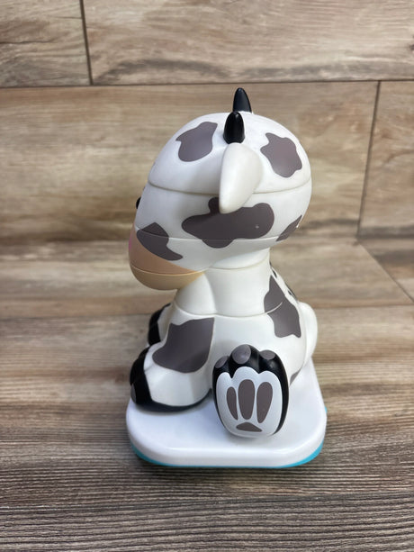 Side view of Stack-a-Roos baby cow stacking toy showing stacked removable sections, gray cow spots and paw base on wood table