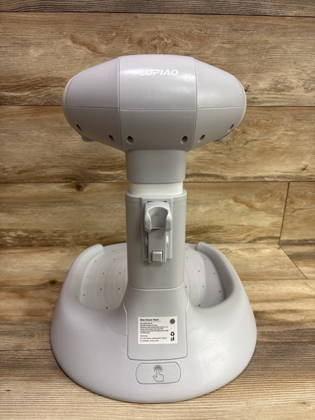 Rear view of Lopiao baby bath stand showcasing its white molded base and central column with a wood background
