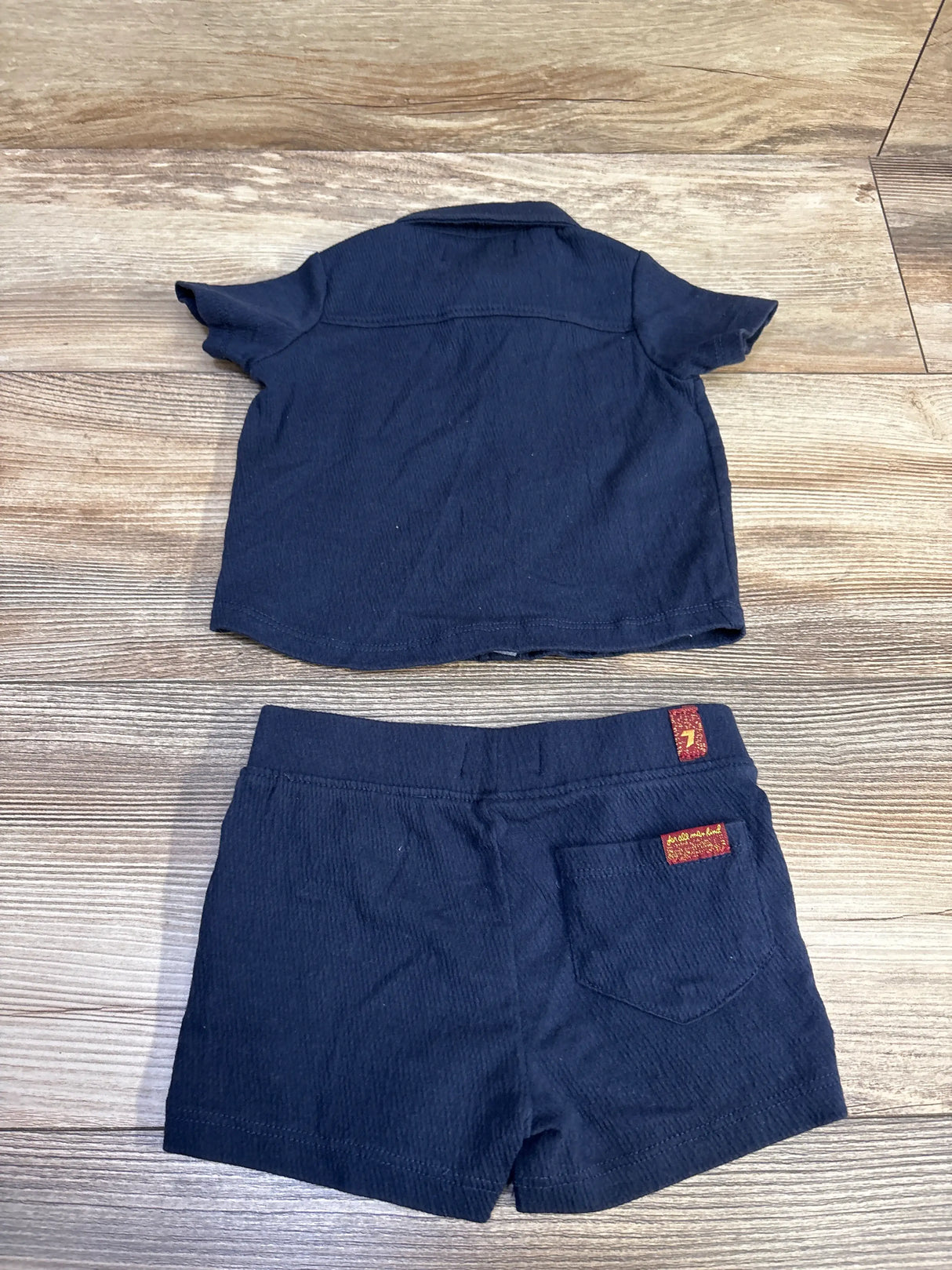 Back view of 7 For All Mankind navy button-up shirt and shorts set showcasing short sleeves and back pocket