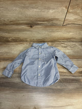 Striped long sleeve button-up toddler shirt on wood background