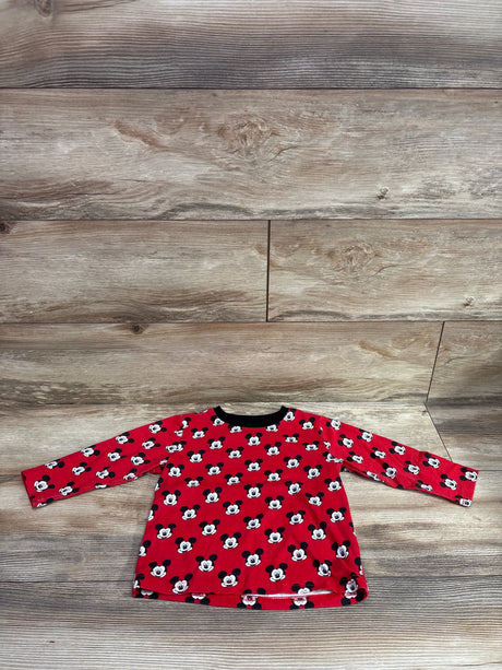 Flat lay of a red Disney Mickey Mouse shirt showcasing long sleeves and an allover character print on a wood-look background
