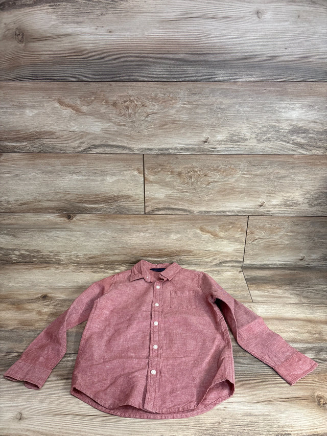 Front view of red linen-cotton long-sleeve button-up shirt (5T) with white buttons and chest pocket on wood background