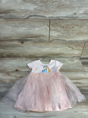 Flat-lay of pink 18m Bluey tulle dress with layered heart-print skirt and short-sleeve Bluey bodice on wood floor