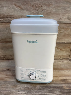 Front view of Papablic baby bottle sterilizer and dryer showing control dial, brand logo, and top lid on a wood surface background