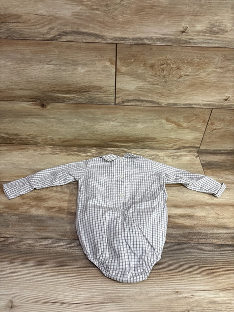 Top view of The Beaufort Bonnet Company white long sleeve collared bubble romper with gray check pattern on a wood floor