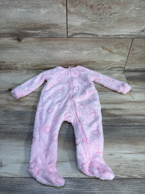 Flat lay of pink Btween plush blanket sleeper with heart pattern, front zipper and built-in feet on wood floor