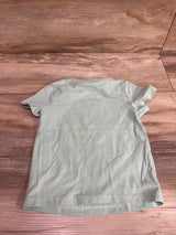 Back view of a light green Cat & Jack baby shirt size 18m on a wooden surface