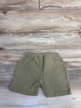 Flat lay of olive Rylee + Cru Sam toddler shorts showing elastic waistband and straight leg on wood background