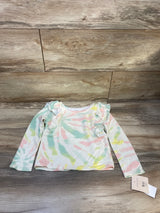 Pastel tie-dye long sleeve toddler shirt with ruffle shoulders on wood background