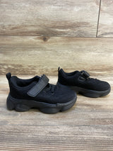 Side view of Anlarach mesh athletic shoes in black showing Velcro strap, knit upper and chunky rubber sole on wood floor