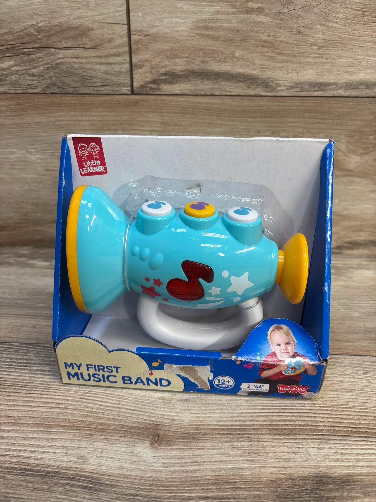 Blue toy trumpet for toddlers, My First Music Band, in box on wood floor, for ages 12 months and up