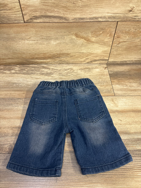 Back view of toddler blue distressed denim shorts size 2T showcasing elastic waistband and two back patch pockets on a wood floor