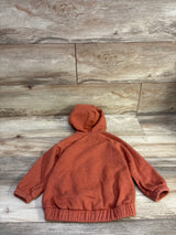 Front view of a rust Old Navy zip hoodie in size 2T showcasing a hood and elastic cuffs and hem on wood planks