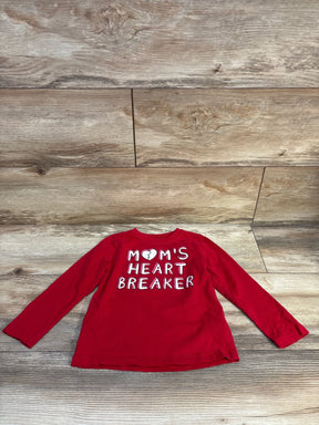 Red long sleeve toddler shirt with 'Mom's Heart Breaker' text, laid on wood floor