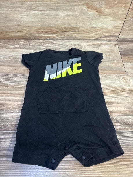 Black short sleeve baby romper with NIKE logo, front pocket, snap bottom, on wood floor