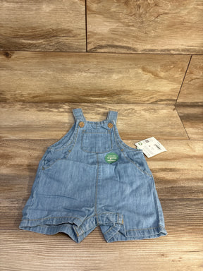 Front view light blue chambray shortall, size 6m, chest pocket, wooden strap buttons, organic cotton tag on wood