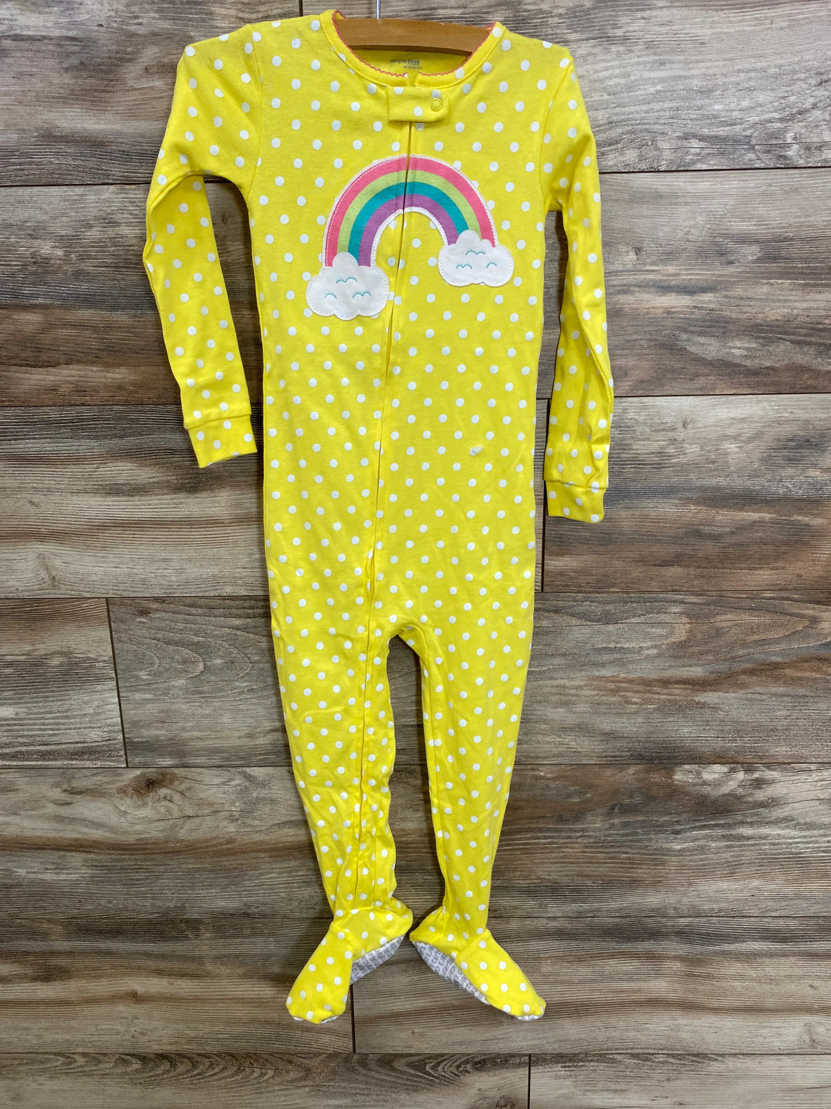 Yellow polka dot baby footed pajamas with rainbow applique, perfect for kids' sleepwear