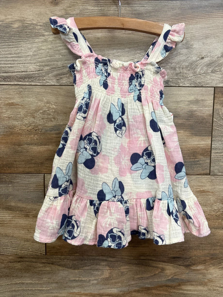 Pink and white toddler sundress with ruffled straps and cartoon mouse print, hanging on wood background