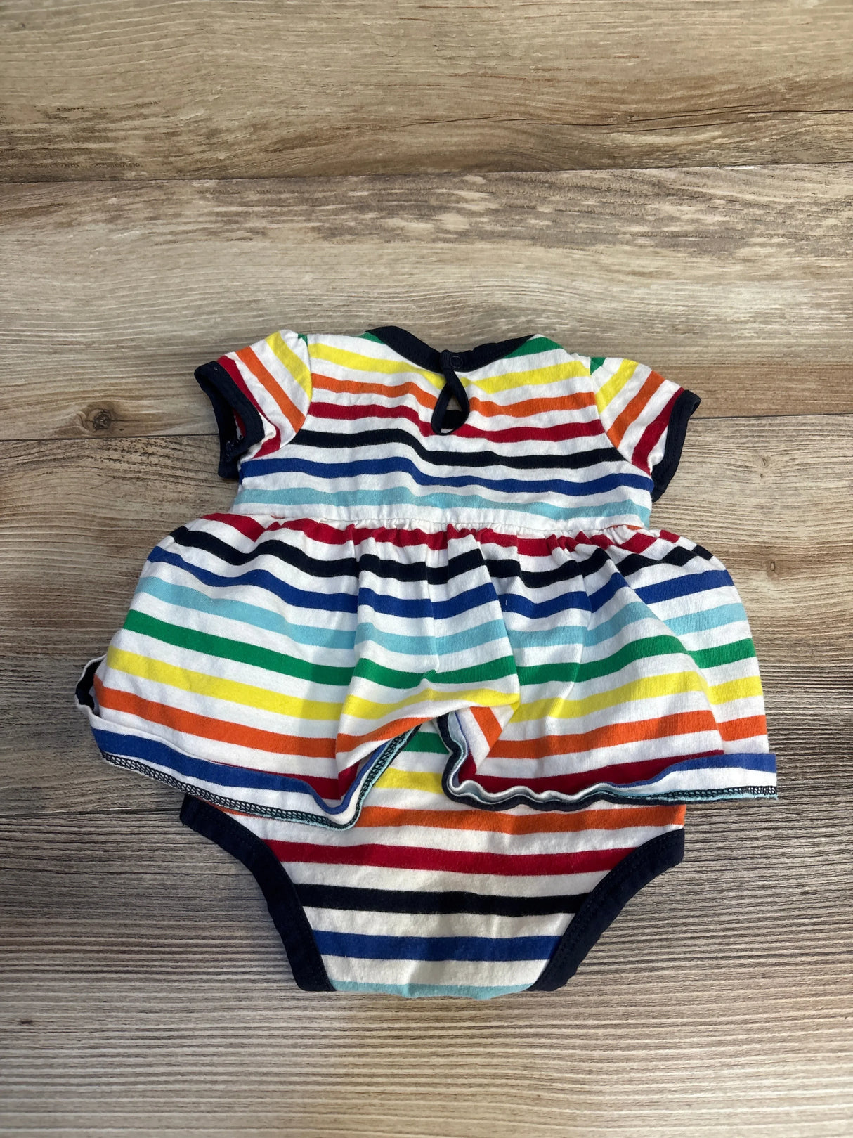 Colorful striped baby romper dress on wood background, gently used children's clothing