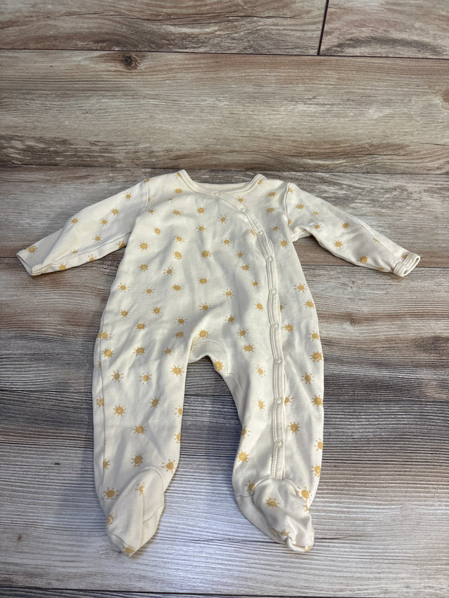 Cream baby onesie with gold sun print, footed design, laid on wood floor