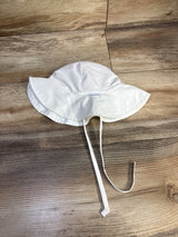 Top-down view of white iPlay by Green Sprouts swim bucket hat showing wide brim and chin ties on wood background