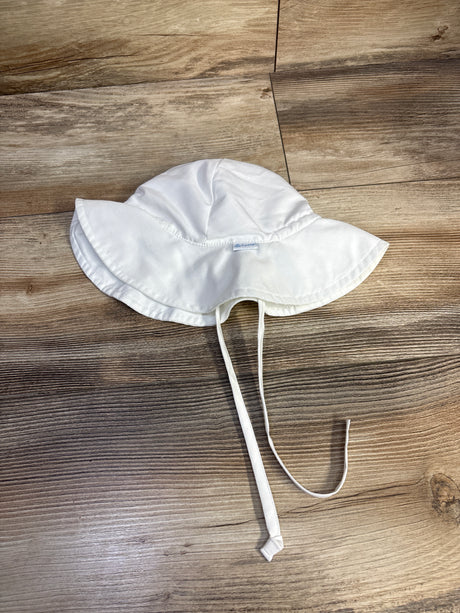 Top-down view of white iPlay by Green Sprouts swim bucket hat showing wide brim and chin ties on wood background