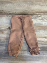 Flat lay of Boys Orchestra tan joggers (12 months) showing elastic drawstring waistband and ribbed cuffs on wooden floor background
