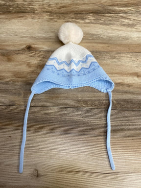 Baby blue and white knit winter hat with pom pom and ear flaps on wooden background