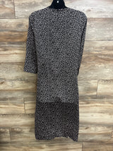 Back view of Hatch Maternity The Lauren dress in black, white speckled print, knee-length, on mannequin with wood background