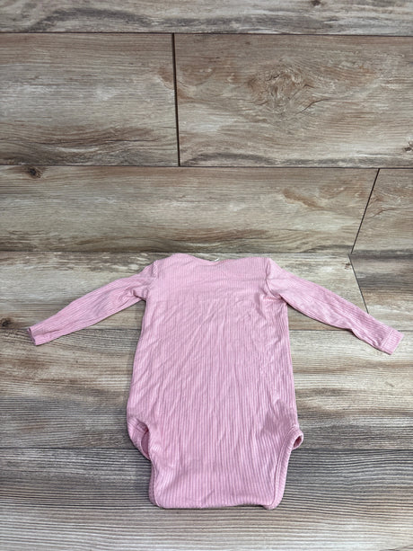 Kate Quinn pink ribbed modal long sleeve baby bodysuit laid flat on a wood background