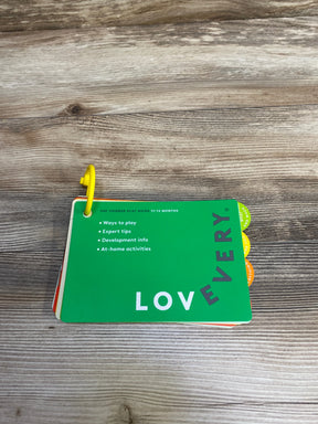 Lovevery 11-12 months play guide cards with tips and activities on wooden surface