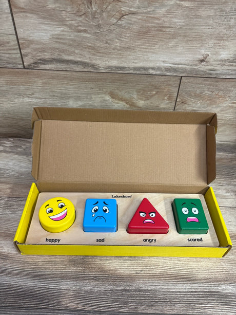 Front view of Lakeshore Emotion Match Puzzle Board showcasing four labeled emotions on a wood-patterned floor