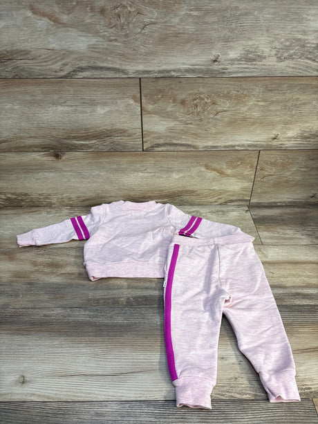 Light pink toddler tracksuit with purple stripes, long sleeve top and matching pants on wood floor