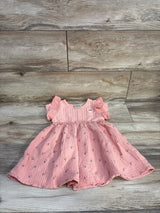 Top-down view of pink Disney Minnie muslin toddler dress size 3T showcasing flutter sleeves and floral skirt on wood