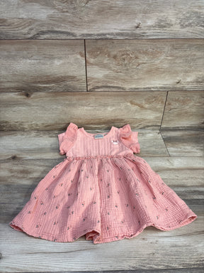 Top-down view of pink Disney Minnie muslin toddler dress size 3T showcasing flutter sleeves and floral skirt on wood