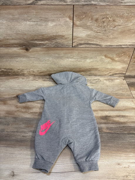 Gray baby hooded jumpsuit with pink Nike logo on wood background